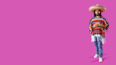 Mor arka planda nachos tutan yakışıklı Meksikalı genç bir adam.