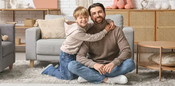 Evde babasına sarılan sevimli küçük bir oğlan. Babalar Günü.