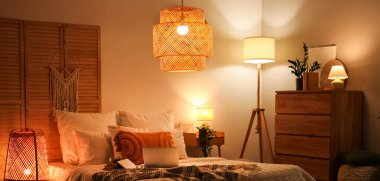 Parlayan lambalar, dizüstü bilgisayarlar ve kitaplarla dolu yatak odasının içi.