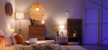 Parlayan lambalar, dizüstü bilgisayarlar ve kitaplarla dolu yatak odasının içi.