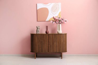 Üzerinde güzel manolya çiçekleri olan bir vazo şık oturma odasındaki çekmeceler.