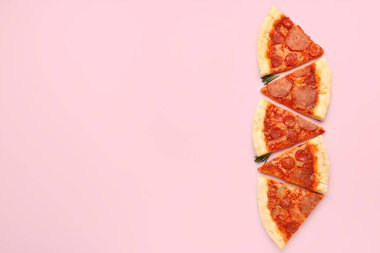 Slices of delicious pepperoni pizza on pink background
