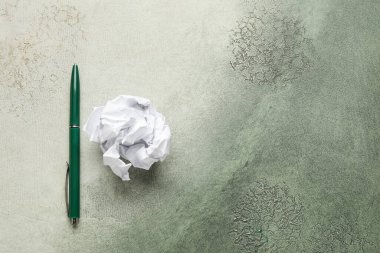 Pen and crumpled paper ball on grunge background. World Poetry Day celebration