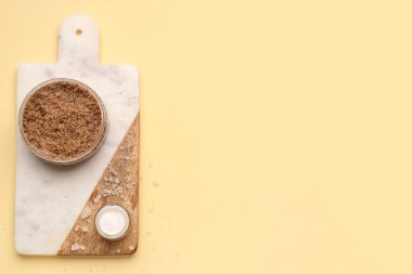 Renk arka planında vücut fırçası, krema ve deniz tuzu olan tahta