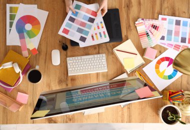 Ofisteki masada renk paletleri ile çalışan kadın grafik tasarımcısı, üst görünüm