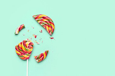 Turkuaz arka planda ezilmiş renkli lolipop