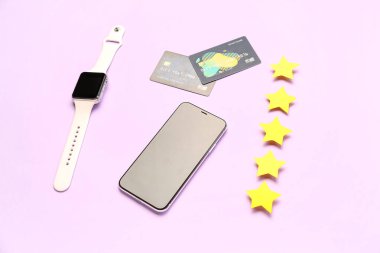 Cep telefonlu beş yıldız, akıllı semer ve eflatun arkaplanlı kredi kartları. Müşteri deneyimi kavramı