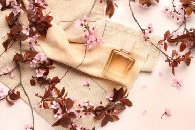 Çiçek açan güzel dallar ve arka planda bir şişe parfüm.