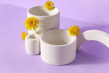 Leylak arka planında karahindiba çiçekleri olan dekoratif podyumlar