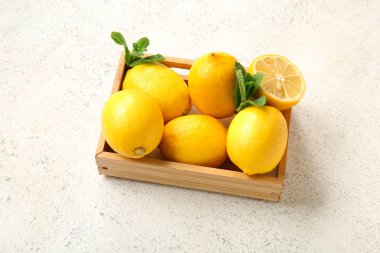 Taze limonlu ahşap kutu ve grunge beyaz arka planda nane.