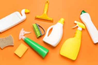 Turuncu arka planda farklı temizlik malzemeleri