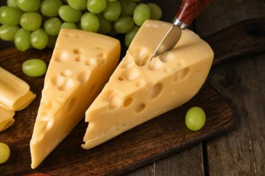 Lezzetli İsviçre peyniri ve ahşap arka planda üzümlü tahta.