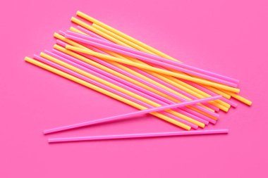 Pembe arka planda farklı plastik pipetler