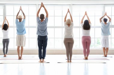 Spor salonunda meditasyon yapan bir grup insan.