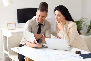 Ofiste dizüstü bilgisayarla çalışan iş danışmanları.