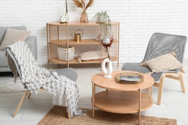 Modern oturma odası. Kahve masası, koltuklar ve raf ünitesi var.