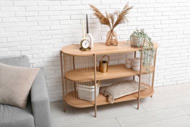 Raflar, bitkiler ve mumlarla dolu modern oturma odası.