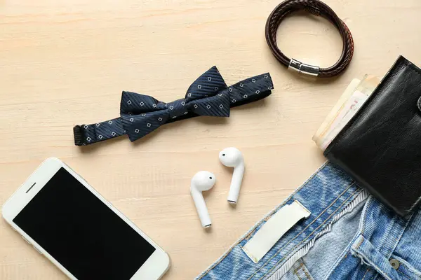 Şık erkek papyonu, cep telefonu, cüzdan ve kotlu kompozisyon açık ahşap arka plan, yakın plan