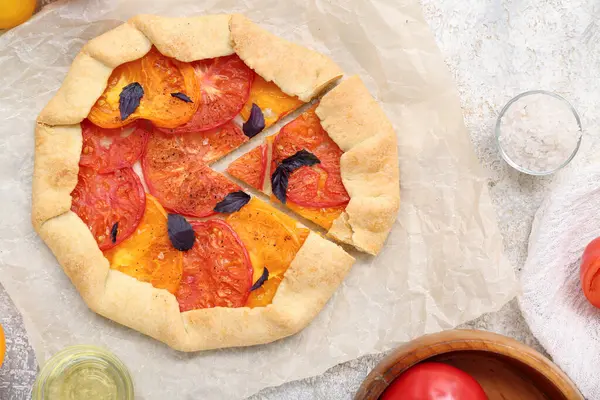 Lezzetli domates galeti ve gri arka planda fesleğen içeren kağıt fırını.