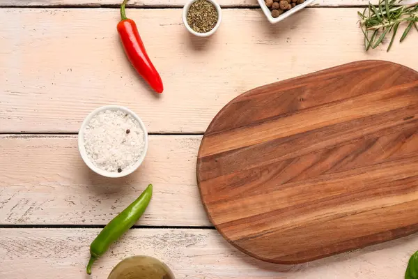 Kesme tahtası ve hafif ahşap zemin üzerindeki baharatlarla kompozisyon