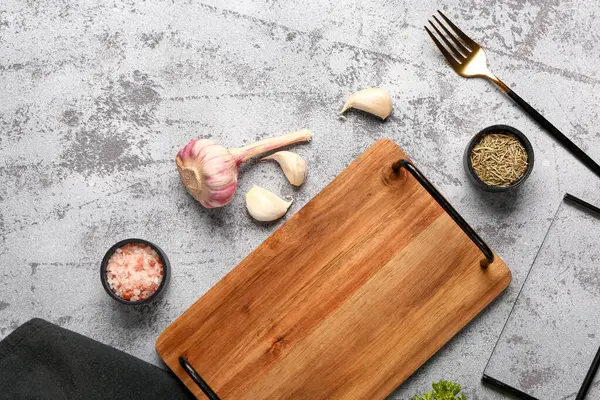 Ahşap mutfak tahtasıyla kompozisyon ve grunge arkaplanda farklı baharatlar