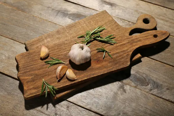 Ahşap zemin üzerinde sarımsak ve biberiye olan yeni kesme tahtaları