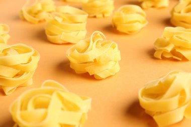 Bej arka planda pişmemiş tagliatelle makarna ile kompozisyon, yakın plan