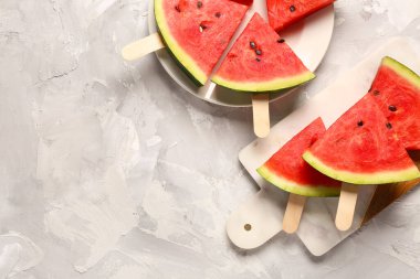 Arkaplanda tatlı karpuz çubukları olan tabak ve yemek.