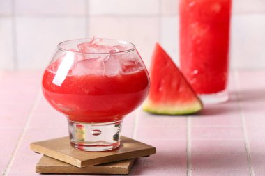 Bir bardak lezzetli karpuz. Pembe fayanslar üzerinde taze.