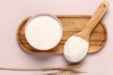 Pembe arka planda un ve buğday kulaklı kase