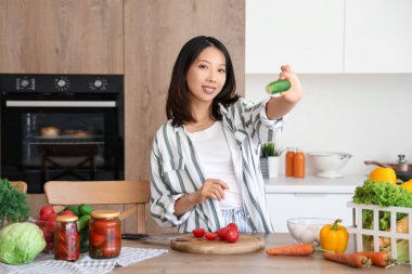 Mutfakta salatalık pişiren güzel bir Asyalı kadın.