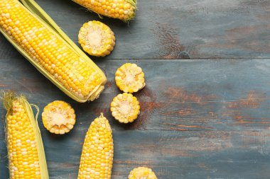 Mavi ahşap arka planda taze mısır koçanları