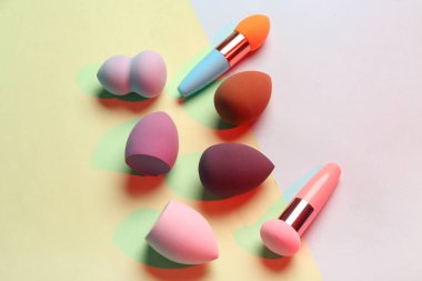 Renkli arkaplanda farklı makyaj süngerleri