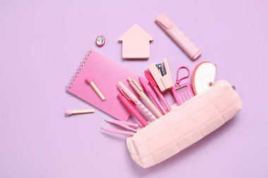 Mor arka planda farklı okul kırtasiyesine sahip kalem kutusu