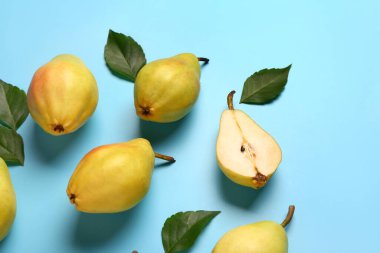 Mavi zemin üzerinde taze armutlar ve yapraklar