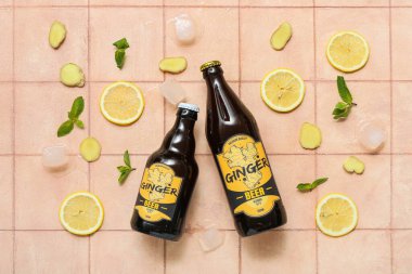 Taze zencefilli bira, nane, limon dilimleri ve bej arka planda buz küpleriyle kompozisyon