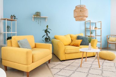 Oturma odasında rahat koltuklar, kanepe ve masa.