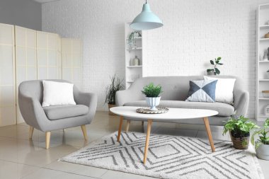 Oturma odasında rahat bir koltuk, kanepe ve masa.