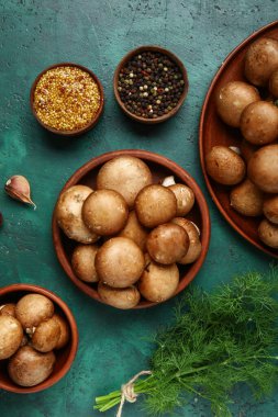 Taze mantarlı kaseler ve yeşil arka planda farklı baharatlar.