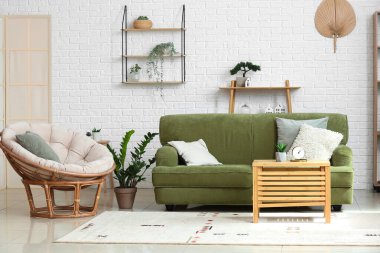 Rahat koltuğu ve yeşil kanepesi olan şık bir oturma odası.