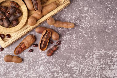 Ahşap tahta tahta ve gri arka planda lezzetli tamarindler.