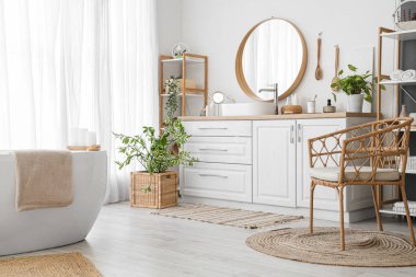 Lavabolu, aksesuarlı ve aynalı bir banyo.