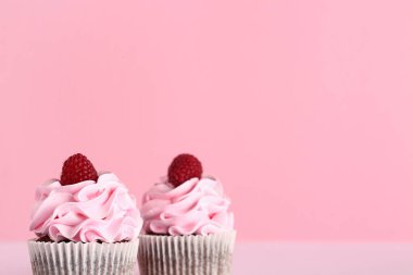 Pembe arka planda lezzetli ahududu kekleri