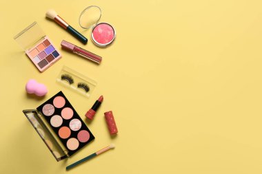 Sarı arka planda farklı dekoratif kozmetik ürünler