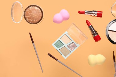 Turuncu arka planda uçan dekoratif kozmetik