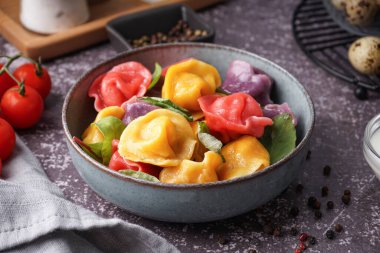 Bir kase kaynamış renkli hamur köftesi, ıspanaklı ve biberli.