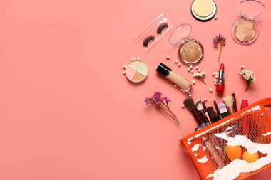 Makyaj ürünleri ve mercan zemin üzerinde güzel çiçekler olan şık kırmızı kozmetik çanta.