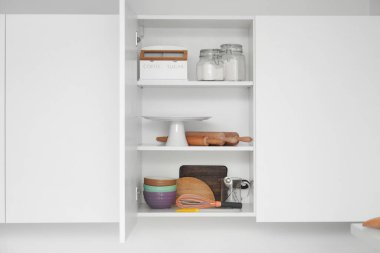 Mutfaktaki fırın için malzeme ve mutfak malzemeleriyle dolu bir dolap.