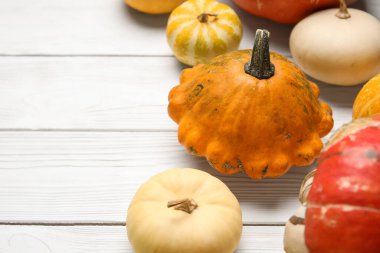 Beyaz ahşap arka planda farklı taze balkabakları