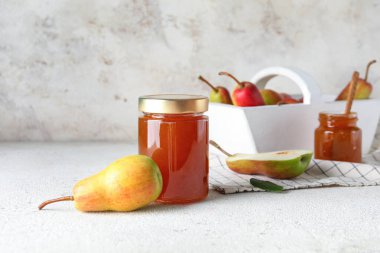 Cam kavanoz armut reçeli beyaz masada.